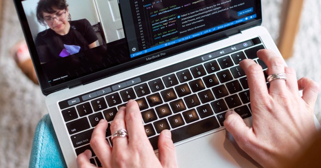 Person coding on a laptop during a video conference, showcasing remote work.